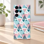 Pink, turquoise and deep teal abstract triangle pattern mobile skin on a white background, oak desk lifestyle
