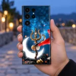 Adiyogi Shiva mobile skin with golden trishul, damru and glowing crescent on cosmic blue, in-hand lifestyle