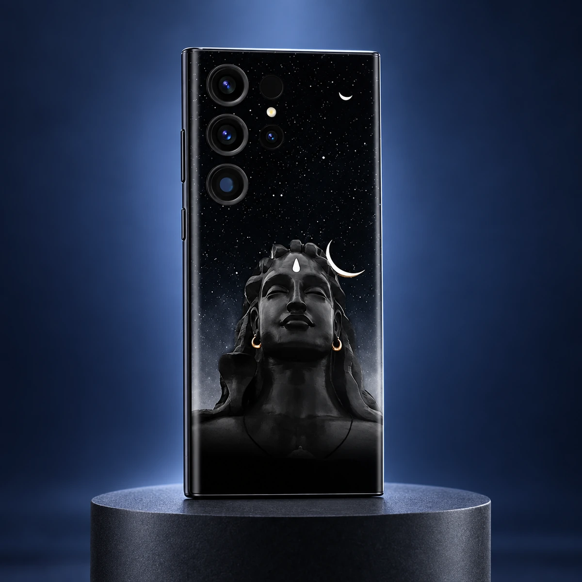 Adiyogi Starry Night Mobile Skin - moonlight studio Adiyogi black starry night mobile skin on a charcoal plinth against an indigo studio background