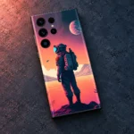 Astronaut mobile skin showing a standing explorer against coral skies and a pink planet, concrete flat lay