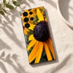 Black Eyed Susan mobile skin with golden yellow petals and dark flower center, linen flat lay
