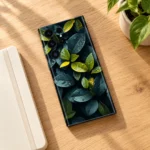 Cinematic Leaves mobile skin with teal and green foliage in oak desk flat lay