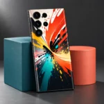 Colorful mobile skin with orange, yellow, teal and black paint splash artwork, sculptural display