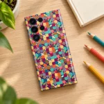 Colorful Pattern mobile skin lying on an oak desk beside coloured pencils