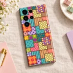 Colourful patchwork mobile skin with floral panels, polka dots, stripes and printed stitch borders, linen flat lay view
