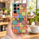 Colourful patchwork mobile skin with floral panels, polka dots, stripes and printed stitch borders, cafe handheld view
