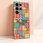 Colourful patchwork mobile skin with floral panels, polka dots, stripes and printed stitch borders, peach studio detail view