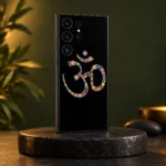 Black floral Om phone skin with tiny multicoloured flowers in an olive studio setting