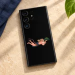 Black Hanuman mobile skin styled on warm stone with navy linen