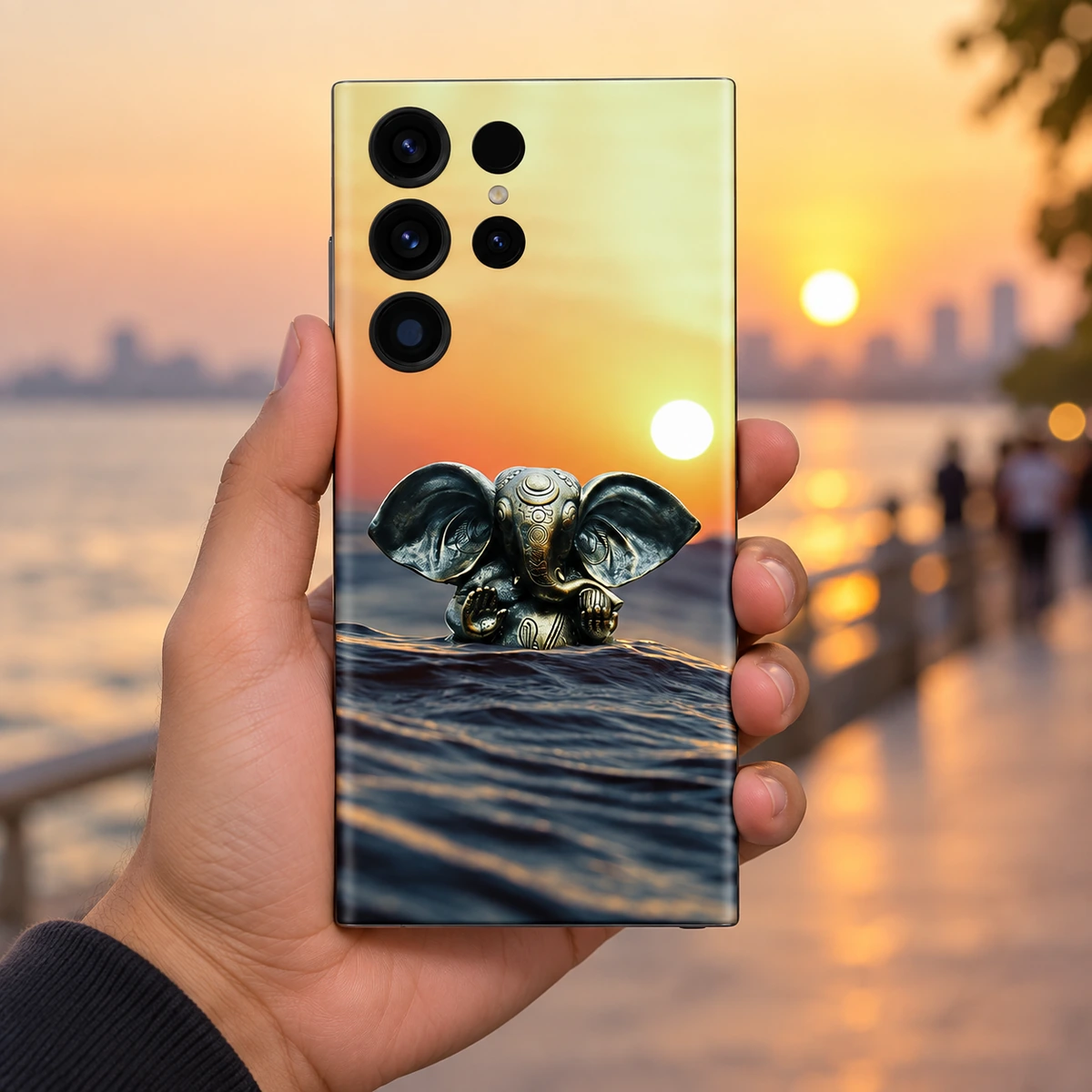 Lord Ganpati Sunset Water Mobile Skin – in-hand lifestyle Lord Ganpati sunset water mobile skin with bronze Ganesha idol – in-hand lifestyle