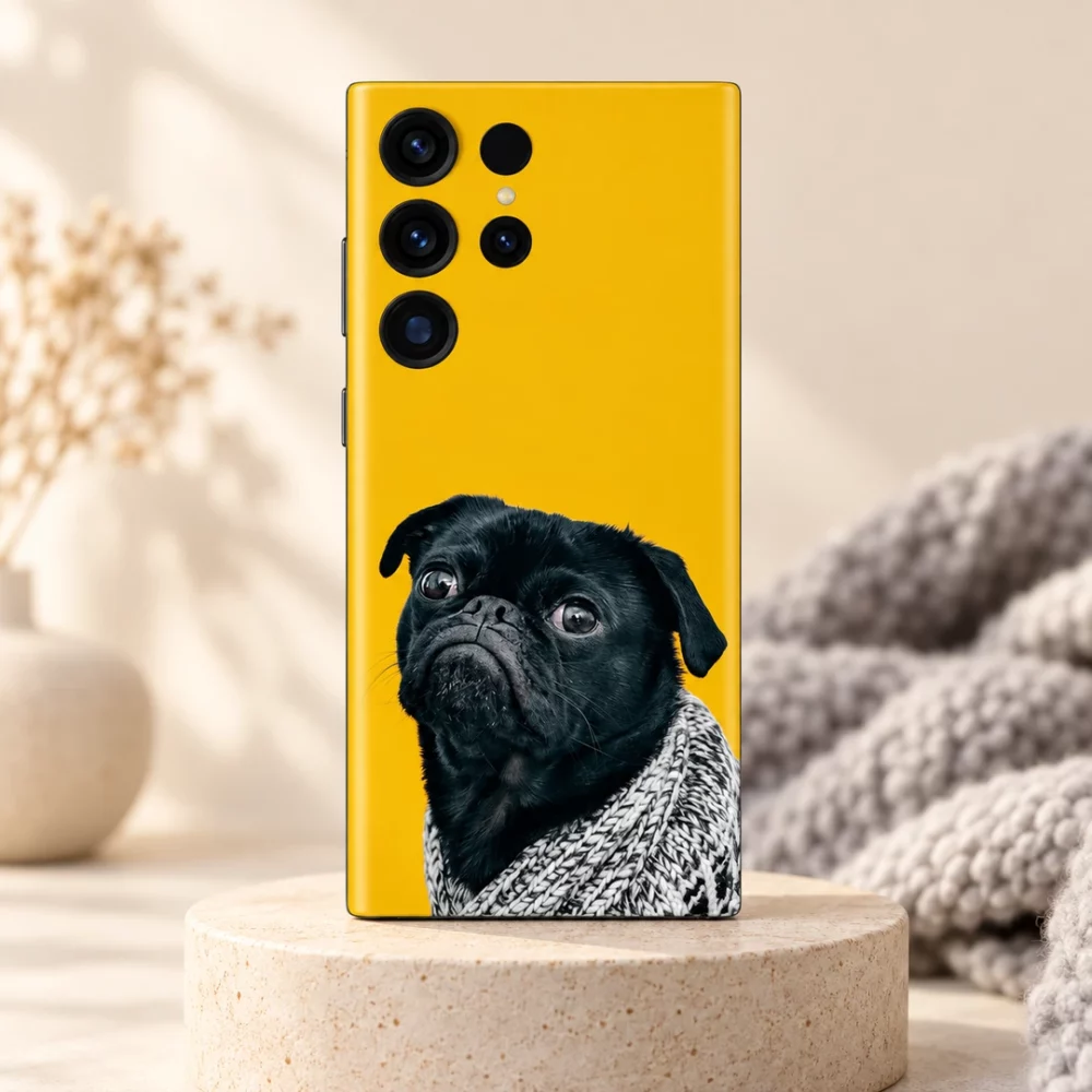 Yellow mobile skin featuring a grumpy black pug in a grey knitted blanket - warm studio hero