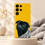 Yellow mobile skin featuring a grumpy black pug in a grey knitted blanket - warm studio hero