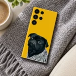 Yellow mobile skin featuring a grumpy black pug in a grey knitted blanket - cozy knit flat lay
