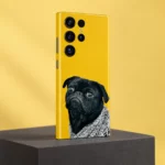 Yellow mobile skin featuring a grumpy black pug in a grey knitted blanket - yellow studio angle