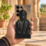 Hanuman black statue mobile skin held in hand in a sunlit sandstone courtyard