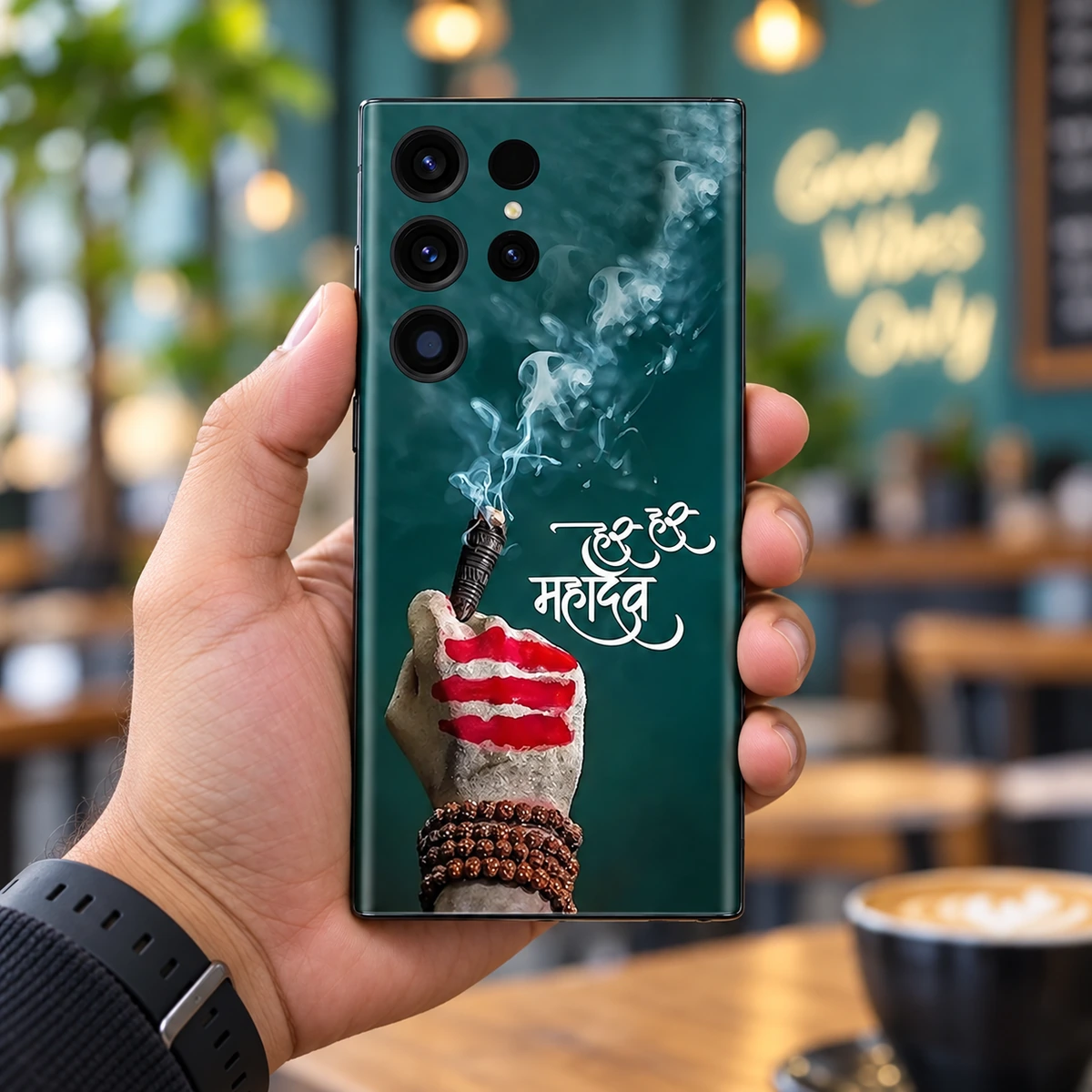 Har Har Mahadev Teal Calligraphy Mobile Skin - Cafe in-hand Har Har Mahadev teal calligraphy mobile skin held in a bright cafe