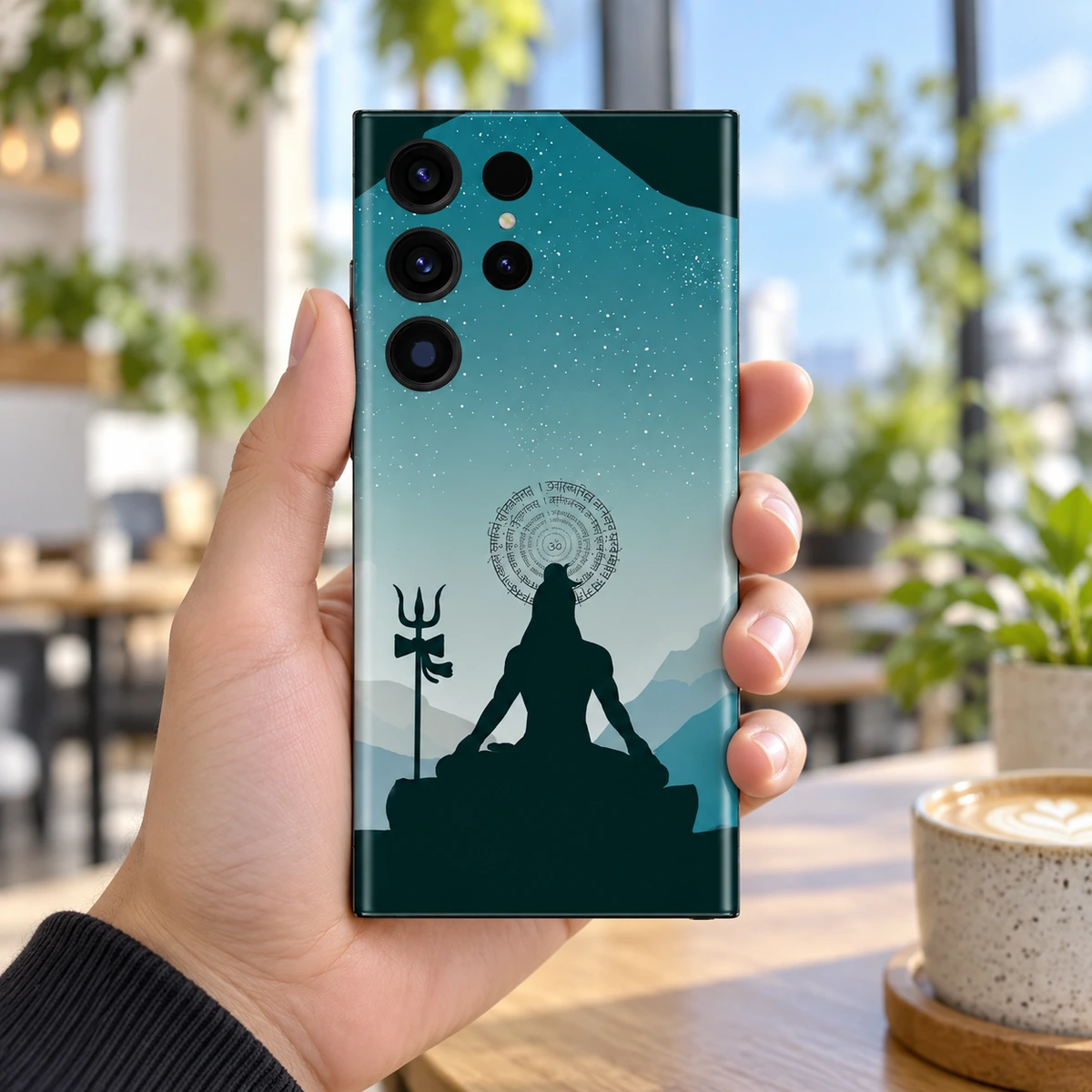 Har Har Mahadev Teal Mountain Meditation Mobile Skin - Cafe in-hand Har Har Mahadev teal meditation mobile skin held in a bright airy cafe