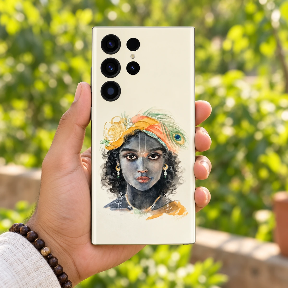 Kanha Watercolour Portrait Mobile Skin - Garden handheld Kanha watercolour portrait mobile skin held in hand against a green garden