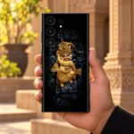 Kashtabhanjan Dev Golden Hanuman Mobile Skin held in hand in a sunlit courtyard