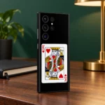 Black King of Hearts card mobile skin with red K symbols, walnut desk angle