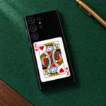 Black King of Hearts card mobile skin with red K symbols, emerald flat lay