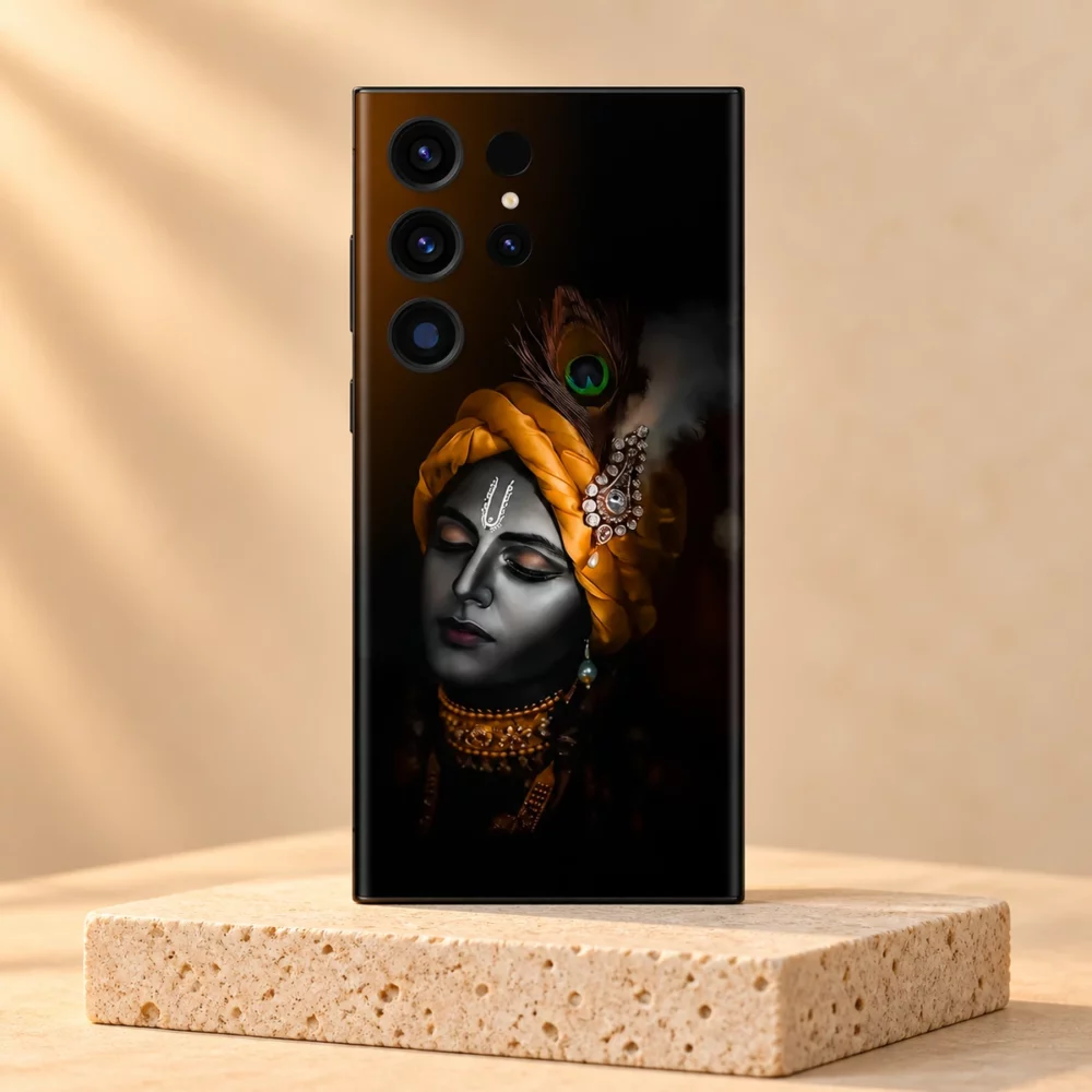 Lord Krishna portrait mobile skin in black and saffron on a pale travertine pedestal