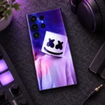Marshmello mobile skin with purple and pink portrait, music desk flat lay