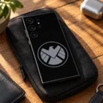 Black Marvel Shield mobile skin with grey circular eagle emblem, everyday carry detail