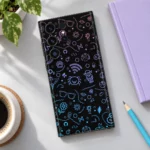 Black motif pattern mobile skin with purple and blue line art doodles, daylight desk flat lay