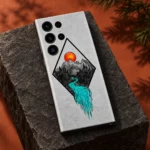 Mountain Art Mobile Skin with orange sun and turquoise river, charcoal plinth studio view