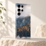Natural Mountain Autumn Forest Mobile Skin shown at an angle on a pale limestone pedestal