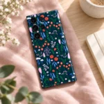 Navy Floral Pattern Mobile Skin shown diagonally on blush linen beside a notebook