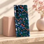 Navy Floral Pattern Mobile Skin shown leaning beside a blush ceramic block