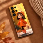 Orange hoodie girl mobile skin with golden autumn artwork, cozy flatlay view