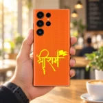 Shree Ram saffron yellow calligraphy mobile skin held in a sunlit cafe