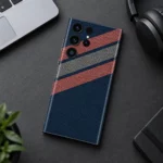 Navy blue mobile skin with coral and grey diagonal stripes and dotted pattern - desk flat lay