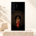 Trishul Damru mobile skin with gold mandala and red ribbons on black displayed on an ivory pedestal