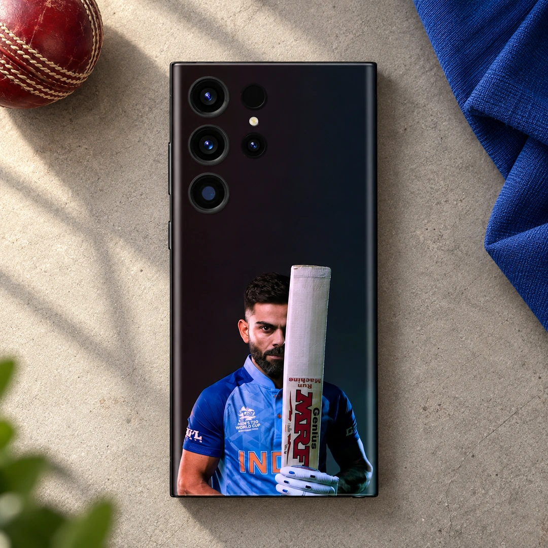 Virat Kohli Bat Portrait Mobile Skin – Cricket desk flat lay Virat Kohli mobile skin showing his blue-jersey portrait behind an upright bat, cricket desk flat lay