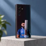 Virat Kohli mobile skin showing his blue-jersey portrait behind an upright bat, concrete studio angle