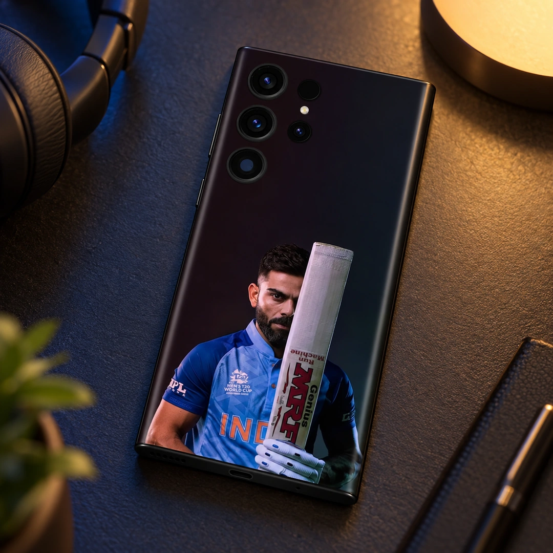 Virat Kohli Bat Portrait Mobile Skin – Evening desk display Virat Kohli mobile skin showing his blue-jersey portrait behind an upright bat, evening desk display