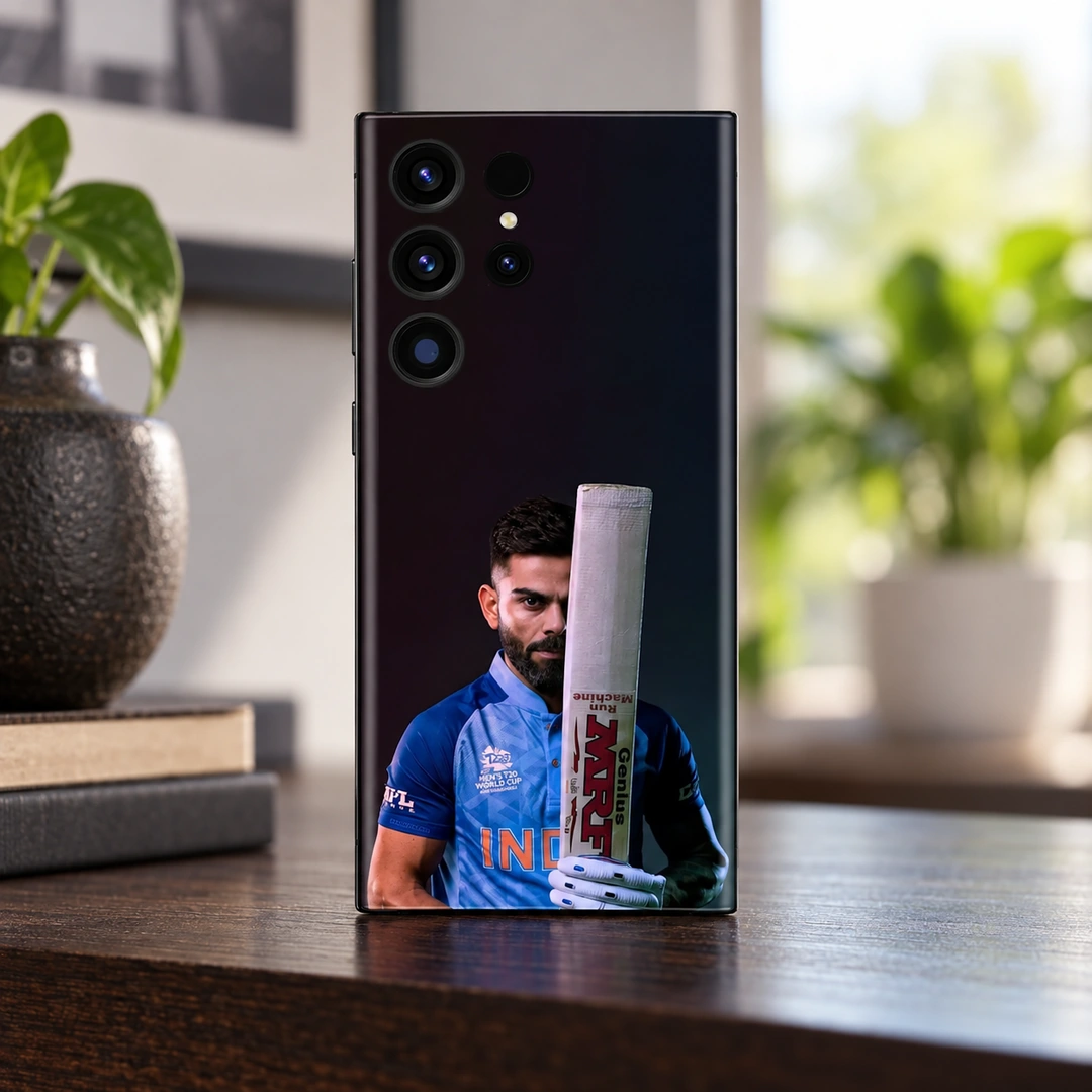 Virat Kohli Bat Portrait Mobile Skin – Daylight wooden shelf Virat Kohli mobile skin showing his blue-jersey portrait behind an upright bat, daylight wooden shelf
