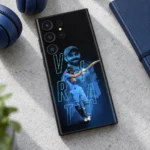 Virat Kohli mobile skin with blue portrait, batting pose and VIRAT outline lettering, modern desk