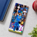 Virat Kohli Photo Mobile Skin with raised bat and blue India jersey, cricket desk flat lay