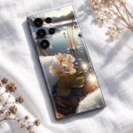 Winter lake mobile skin with cream-white flowers, snowy banks and golden water reflections, linen flat lay view