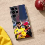 Dhoni and Virat Kohli smiling in yellow and red cricket jerseys on a mobile skin, cricket table flat lay