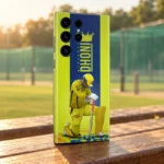 Yellow Dhoni photo mobile skin with crown, vertical MAHENDRA DHONI lettering and kneeling cricketer, practice ground bench