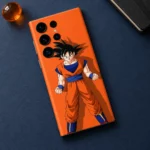 Orange Goku mobile skin with black-haired character artwork, navy flat lay