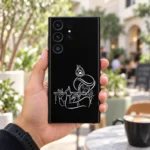 Krishna flute outline mobile skin with white turban and peacock feather line art on black – in-hand lifestyle