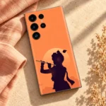 Krishna sunset silhouette mobile skin with flute and pale sun on coral orange – linen flat lay