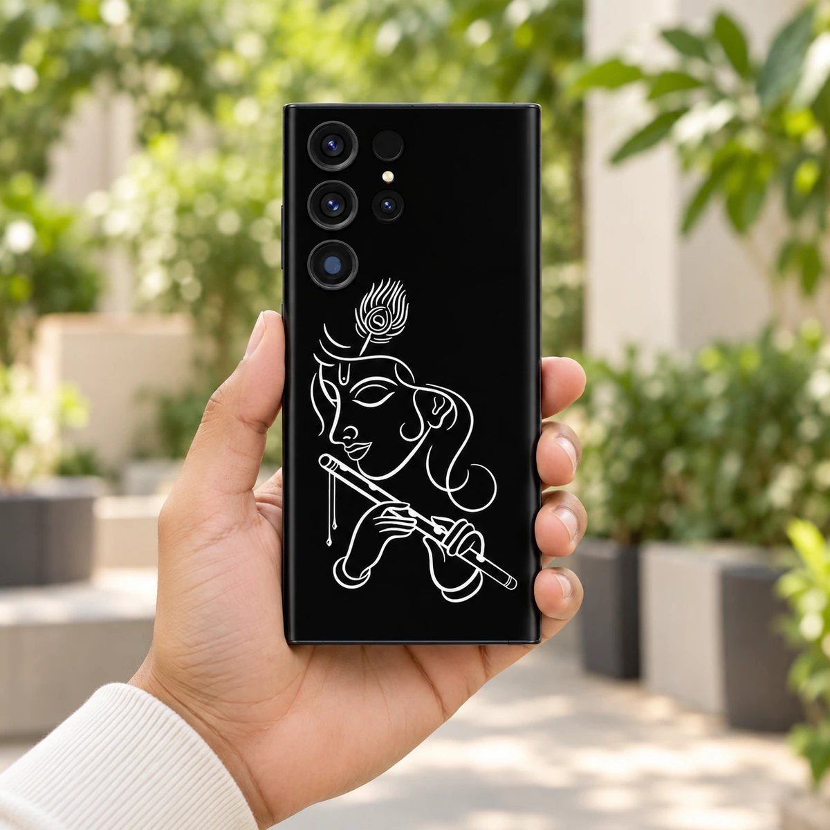 Krishna White Line Art Mobile Skin - Garden handheld Handheld Krishna white line art mobile skin showing flute and peacock feather in a garden courtyard